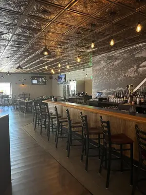 a bar with a row of chairs in a restaurant at Best Western Plus Clarks Summit Scranton Hotel in Clarks Summit