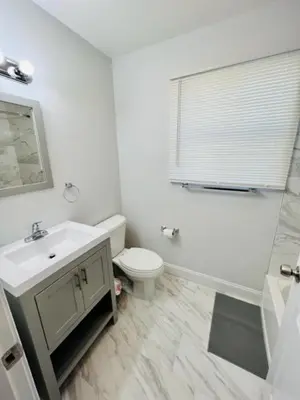 a white bathroom with a sink and a toilet at Cozy & Deluxe Apartment - EZ Access to NYC in Newark