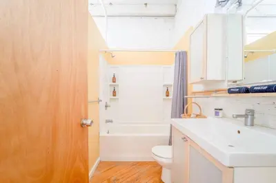 a bathroom with a sink and a toilet and a tub at Cool Urban Stay Dtwn Apt And Patio in Binghamton