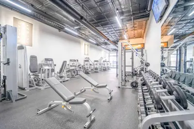 a gym with rows of exercise bikes and treadmills at Cool Urban Stay Dtwn Apt And Patio in Binghamton