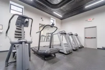 a row of exercise bikes in a gym at Cool Urban Stay Dtwn Apt And Patio in Binghamton