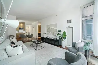 a living room with a couch and chairs and a kitchen at Times Square Penthouse in New York