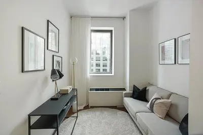 a living room with a couch and a table and a window at Times Square Penthouse in New York