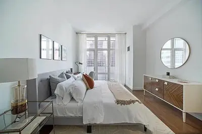 a white bedroom with a large bed and a desk at Times Square Penthouse in New York