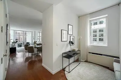 a white living room with a table and a dining room at Times Square Penthouse in New York
