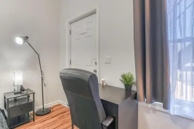 a desk with a chair in a room with a window at Gorgeous Duplex with parking by JSQ in Jersey City
