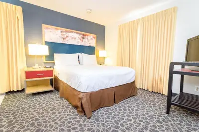 a hotel room with a large bed and a television at Philadelphia Suites at Airport - An Extended Stay Hotel in Philadelphia