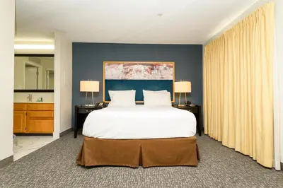 a bedroom with a large bed and two lamps at Philadelphia Suites at Airport - An Extended Stay Hotel in Philadelphia