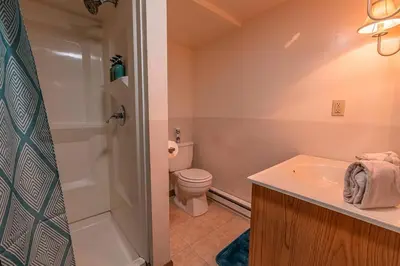 a bathroom with a toilet and a sink and a shower at Cheerful Chalet - Fireplace, BBQ, Firepit& Hottub in Long Pond