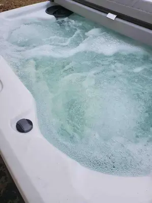 a bath tub filled with blue water in a sink at Cheerful Chalet - Fireplace, BBQ, Firepit& Hottub in Long Pond