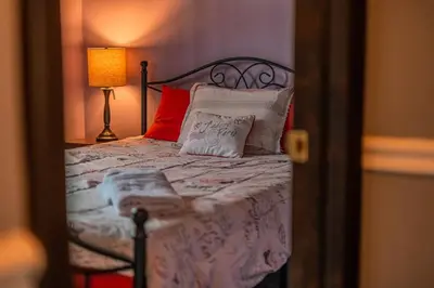 a bedroom with a bed with red pillows and a lamp at Cheerful Chalet - Fireplace, BBQ, Firepit& Hottub in Long Pond