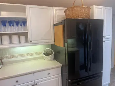 a kitchen with a black refrigerator and white cabinets at Jersey home, close to New York City fun! in Englewood