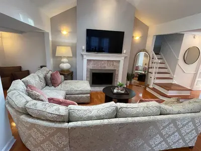 a living room with a couch and a fireplace at Jersey home, close to New York City fun! in Englewood