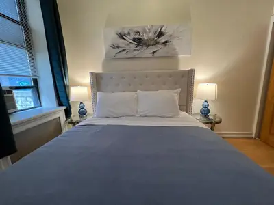 a bedroom with a large bed with a blue blanket at Steps from Empire State Building in New York