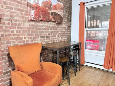 an orange chair sitting next to a brick wall at Steps from Empire State Building in New York
