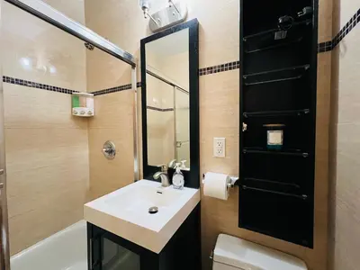 a bathroom with a sink and a toilet and a mirror at Steps from Empire State Building in New York