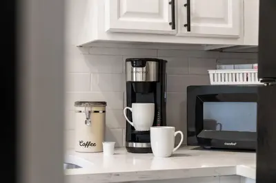 a kitchen counter with a coffee maker and coffee cups at Center City Philadelphia 1BR Apartment Sleeps 4, Walk to Attractions in Philadelphia