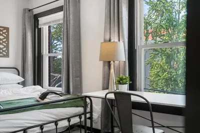 a bedroom with a bed and a desk and windows at Center City Philadelphia 1BR Apartment Sleeps 4, Walk to Attractions in Philadelphia