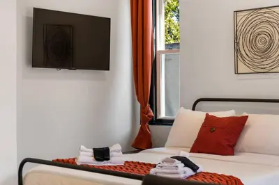 a bedroom with a bed and a window and a television at Charming 2BR Philadelphia Retreat with Free Parking in Philadelphia