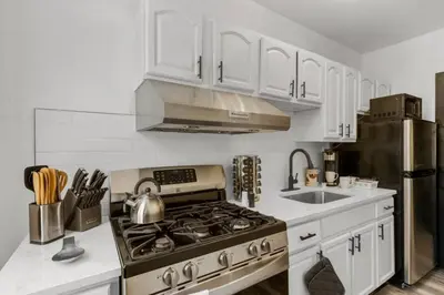 a kitchen with a stove and a stainless steel refrigerator at Charming 2BR Philadelphia Retreat with Free Parking in Philadelphia