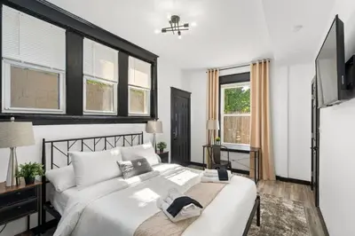 a bedroom with a large white bed and windows at Stylish 3BR Philly Retreat with Free Parking in Philadelphia