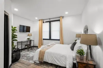a bedroom with a bed and a desk and a window at Stylish 3BR Philly Retreat with Free Parking in Philadelphia