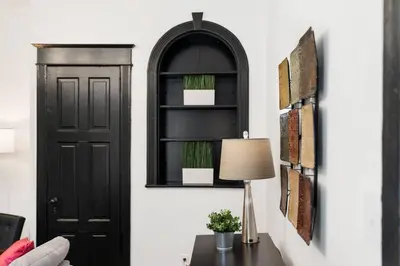 a room with a black door and a table with a lamp at Stylish 3BR Philly Retreat with Free Parking in Philadelphia