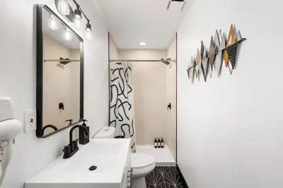 a white bathroom with a sink and a toilet at Stylish 3BR Philly Retreat with Free Parking in Philadelphia