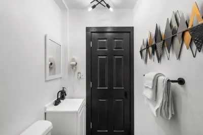 a bathroom with a toilet and a black door at Stylish 3BR Philly Retreat with Free Parking in Philadelphia