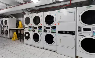 a row of washing machines in a laundry room at 73-519 New Studio UWS Doorman Gym in New York