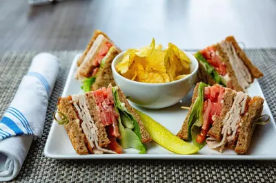 a white plate with sandwiches and a bowl of chips at Element Harrison-Newark in Harrison