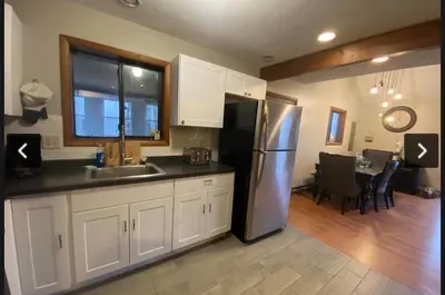 a kitchen with a stainless steel refrigerator and a dining room at Rosie’s Cabin in Thornhurst
