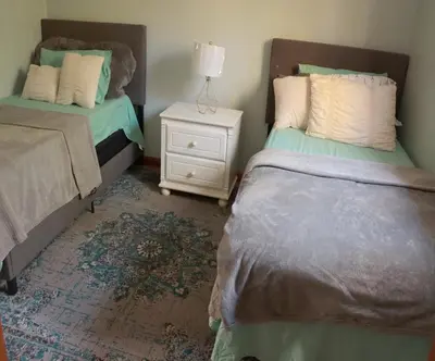 a bedroom with two beds and a night stand at Rosie’s Cabin in Thornhurst