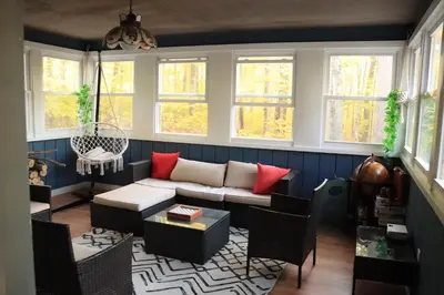 a living room with a couch and some windows at Rosie’s Cabin in Thornhurst