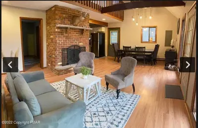 a living room with a couch and chairs and a fireplace at Rosie’s Cabin in Thornhurst