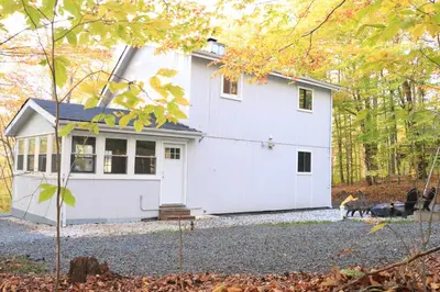 a white house with a dog in front of it at Rosie’s Cabin in Thornhurst