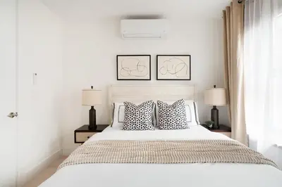 a white bedroom with a large bed with two lamps at 48-4FW Newly renovated W D Midtown in New York