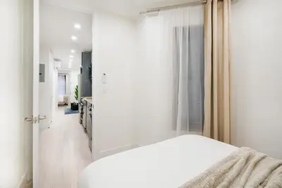a white bedroom with a bed and a window at 48-4FW Newly renovated W D Midtown in New York