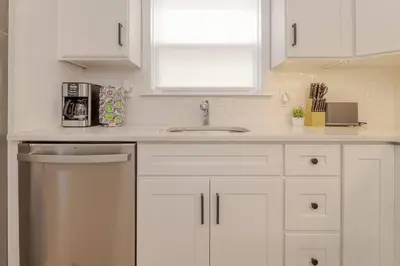 a kitchen with white cabinets and a sink and a window at Beautiful 3bedroom apartment in Elizabeth
