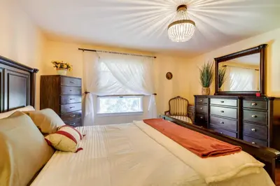 a bedroom with a large bed with a dresser and a mirror at 11 Mi to Slopes! Poconos Lake House with Beach in Pocono Summit