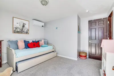 a living room with a couch with colorful pillows at 11 Mi to Slopes! Poconos Lake House with Beach in Pocono Summit
