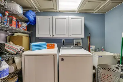 a kitchen with white cabinets and a washer and dryer at 11 Mi to Slopes! Poconos Lake House with Beach in Pocono Summit