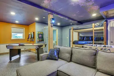 a living room with a couch and a ping pong table at 11 Mi to Slopes! Poconos Lake House with Beach in Pocono Summit