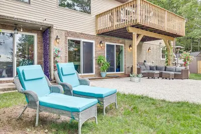 a patio with two chairs and a deck at 11 Mi to Slopes! Poconos Lake House with Beach in Pocono Summit