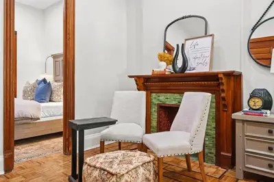 a living room with two chairs and a fireplace at Newly Renovated 2BR Haven Walk to Columbia Uni in New York