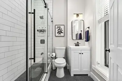a bathroom with a toilet and a glass shower at Newly Renovated 2BR Haven Walk to Columbia Uni in New York
