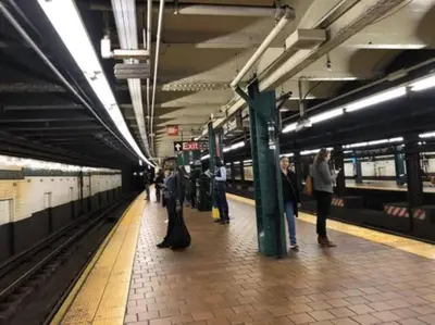 a group of people waiting for a train at a subway station at Newly Renovated 2BR Haven Walk to Columbia Uni in New York