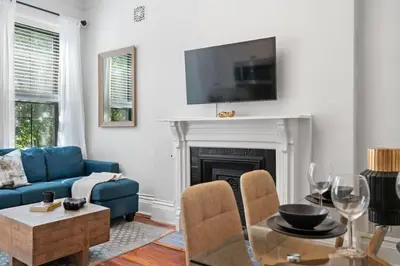 a living room with a blue couch and a fireplace at Newly Renovated 3BR Oasis Walk to Columbia Uni in New York