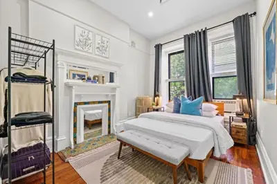 a white bedroom with a bed and a fireplace at 3BR Retreat Walkable to Columbia University in New York