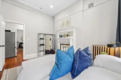 a living room with a white couch and blue pillows at 3BR Retreat Walkable to Columbia University in New York